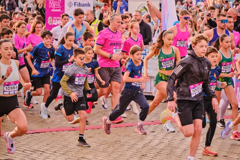 A tightly packed group of young runners taking their first strides.