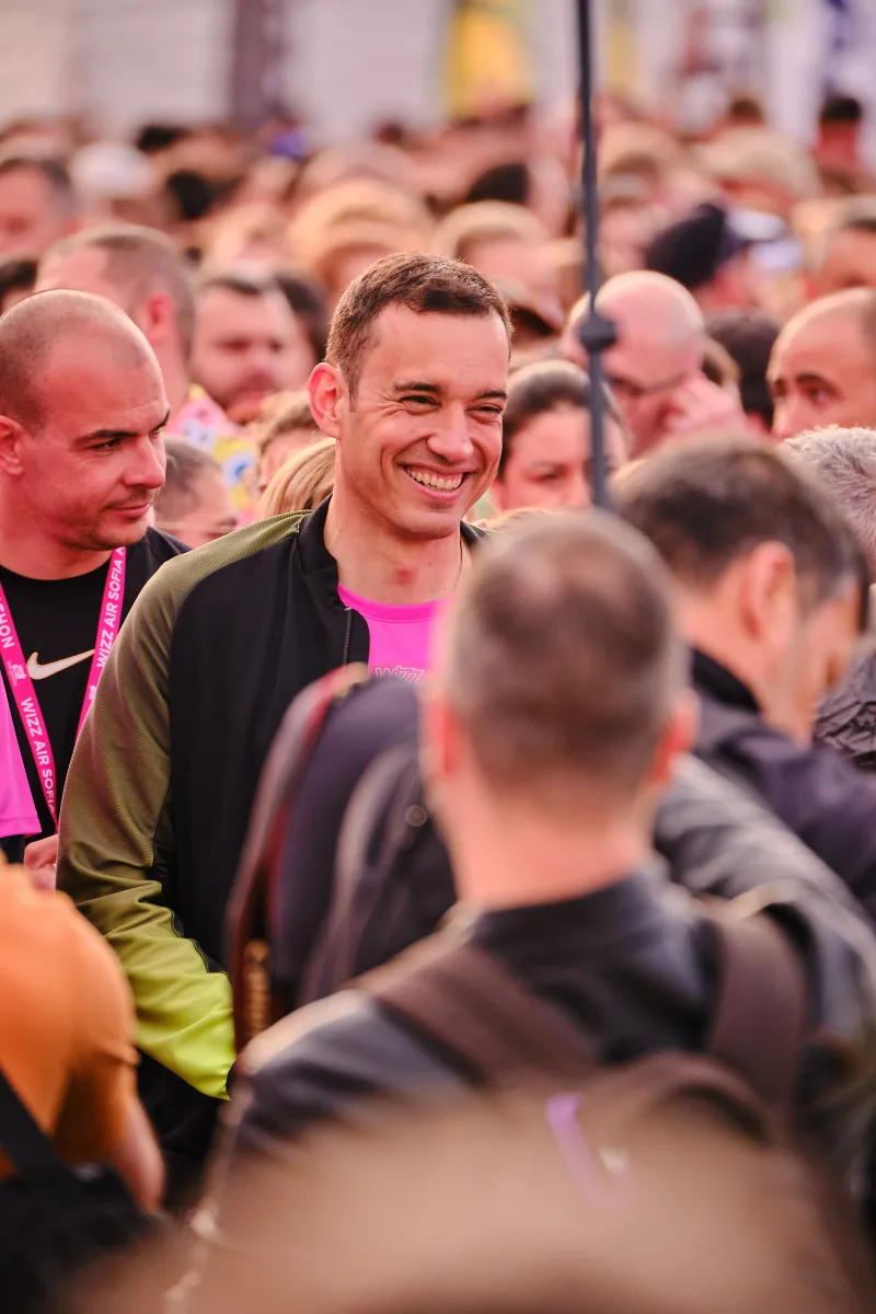 A smiling runner surrounded by participants before the start.