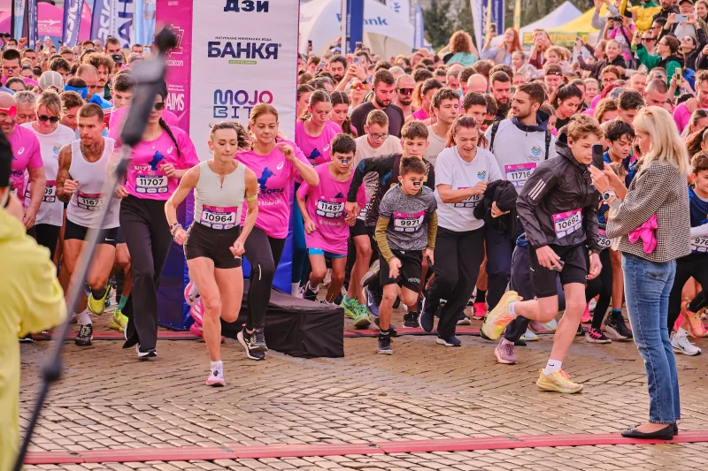 The first rows of runners setting off across the cobblestones.