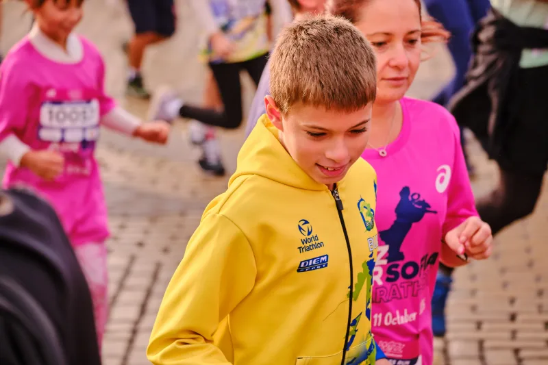 A young participant in a yellow sports shirt looking down.