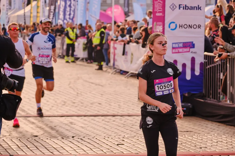 A woman in a black running kit approaching through the square.