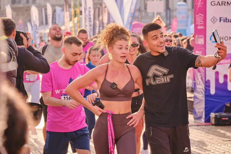 Participants posing together while one holds a phone out for a photograph.