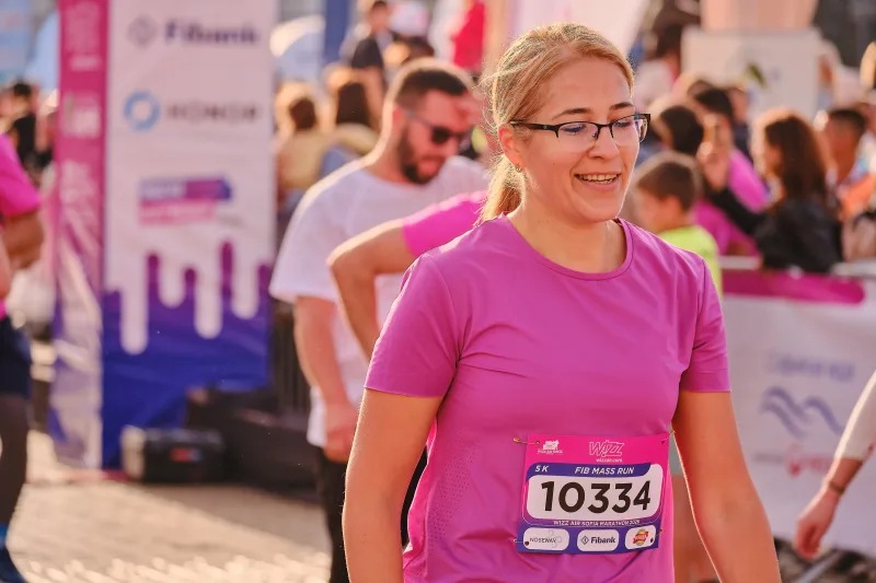 A smiling participant in glasses and a pink shirt.