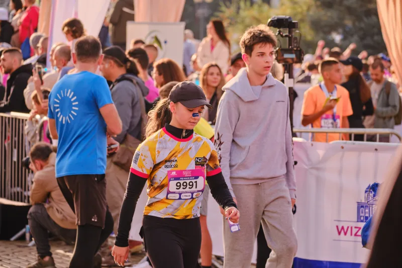 Two young participants standing beside the barriers after passing through the square.