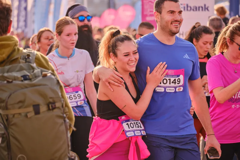 A woman with an arm around a runner in a blue shirt.