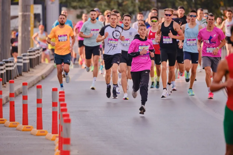 Runners spreading across the street as the field approaches the camera.