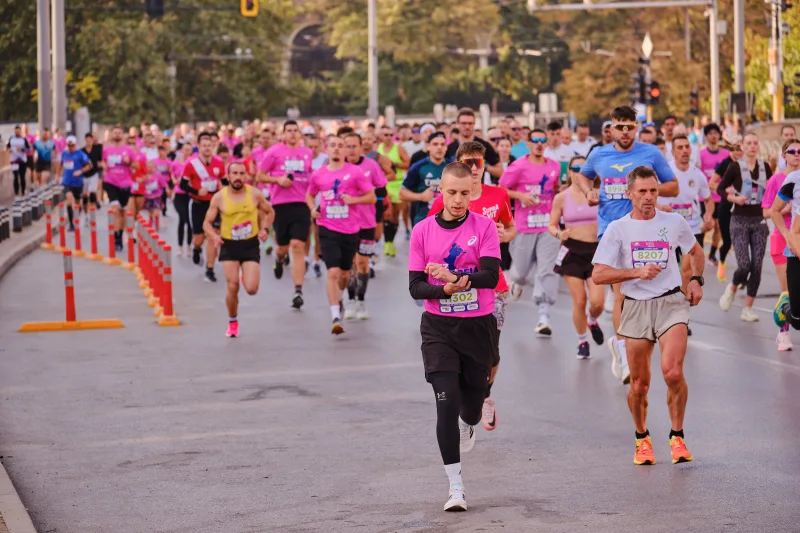 A wide view of runners filling the road beside the tram tracks.