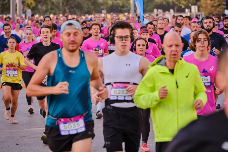 Runners in turquoise, white and lime green at the front of a busy group.