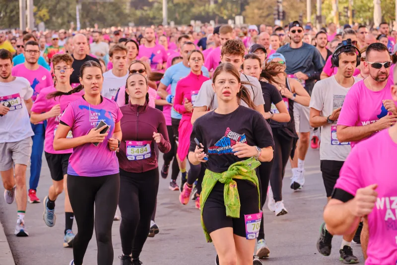 A runner with a jacket tied around her waist approaching among the crowd.