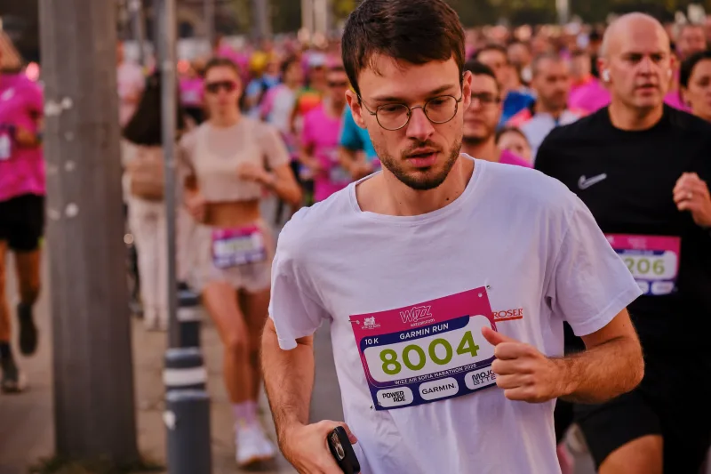 A close view of a runner in glasses and a white shirt.