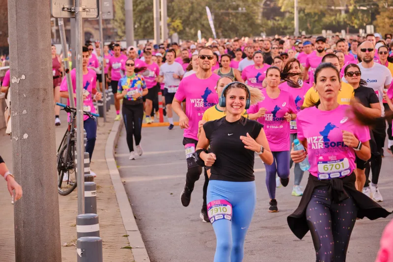 Two women in black and pink running side by side.