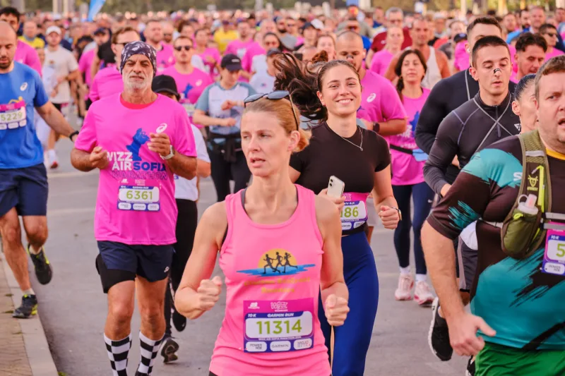 A runner in a pink sleeveless top with lime green trim approaching.