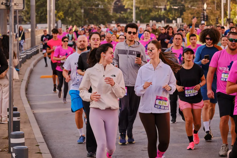 Two participants in pale hoodies running side by side.