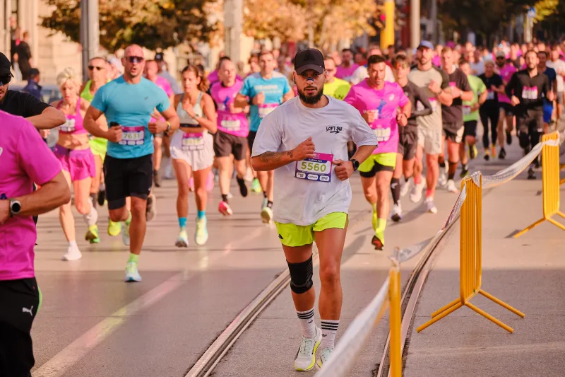 A runner in a pale shirt and bright shorts approaching the camera.