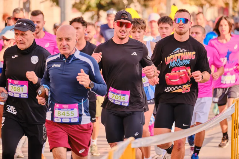 Runners in navy and black following the barrier-lined route.