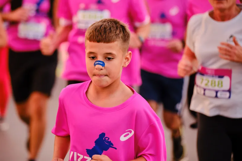 A young participant in a pink shirt with blue face paint.