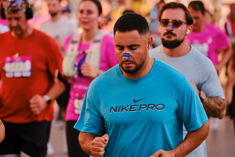 A close view of a runner in a turquoise shirt.