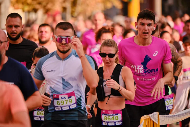 A man in a pale blue top beside a woman in a black running vest.