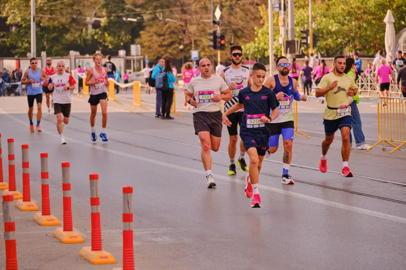 Runners spaced out across the road beside the tram tracks.
