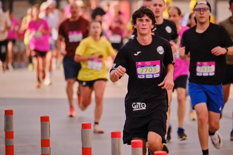 A young participant in a black sports kit running towards the camera.