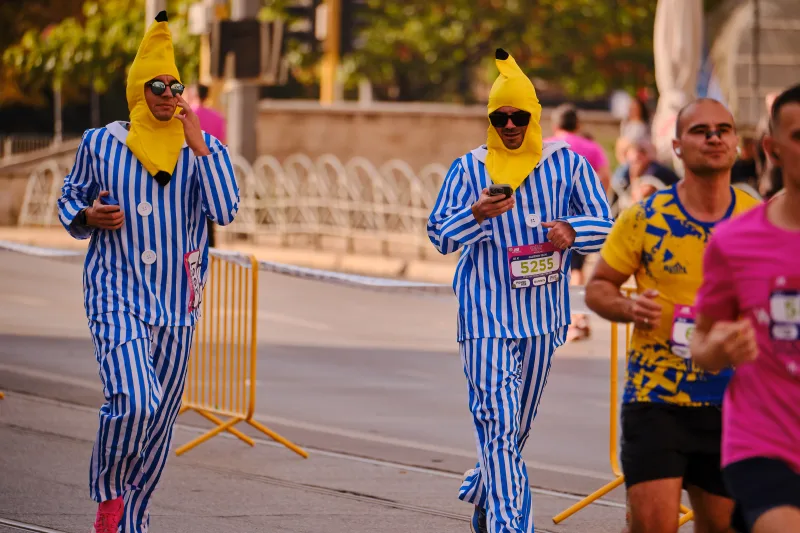 Two runners in blue striped costumes with yellow banana hoods.
